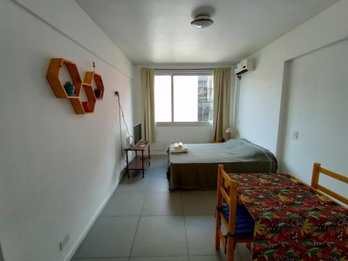 um pequeno quarto com uma cama e uma janela em Departamento con pileta Almagro em Buenos Aires