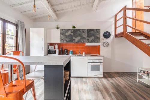 eine Küche mit weißen Schränken und einer orangefarbenen Kachelwand in der Unterkunft Design Center Florence APT - HomeUnity in Florenz