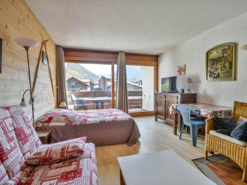 um quarto de hotel com uma cama e uma sala de estar em Studio Morzine, 1 pièce, 2 personnes - FR-1-684-51 em Morzine