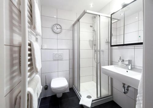 ein Bad mit einem WC, einem Waschbecken und einer Dusche in der Unterkunft Hotel Rosenhof GmbH in Ramstein-Miesenbach
