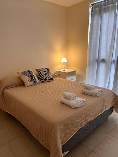 a bedroom with a large bed with towels on it at Departamentos Hipolito Yrigoyen in San Rafael