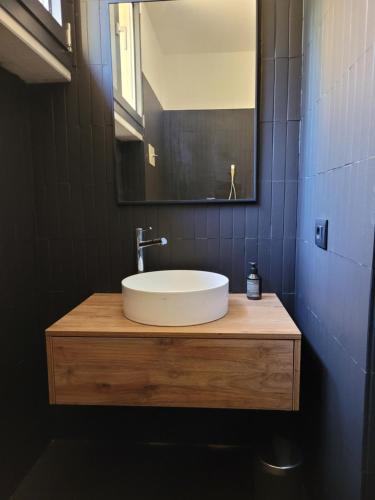a bathroom with a white sink and a mirror at La maison sur mer in Torri del Benaco