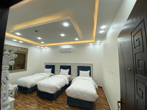 2 Betten in einem Zimmer mit weißen Wänden in der Unterkunft Treasury Terrace Apartments in Wadi Musa