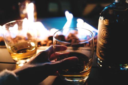 a person holding a glass next to a bottle of alcohol at Jackalope Motor Lodge in Pinedale