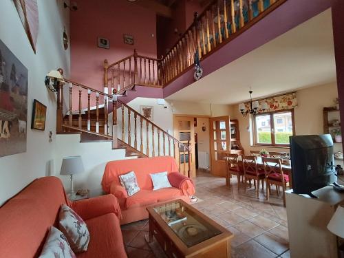 sala de estar con sofá rojo y escalera en Cuarenta y Ocho Luces, en Burgos