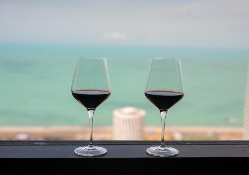 two glasses of red wine sitting on a window sill at Season Suite Apart-Hotel in Batumi