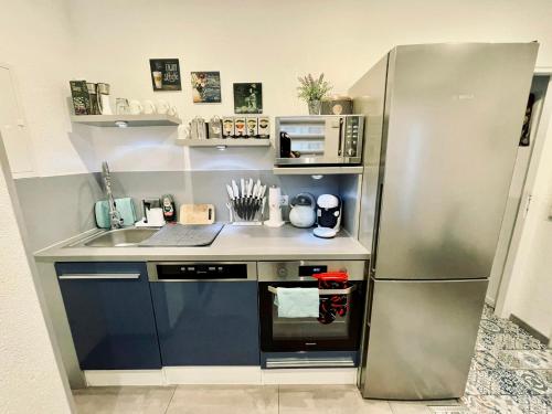 a kitchen with a stainless steel refrigerator and a sink at 2 Room Galerie Einliegerwohnung in Rheinstetten, Messe Nähe, Rollstuhlfahrer geeignet in Rheinstetten