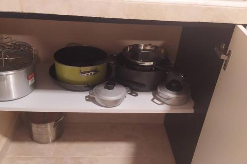 a shelf with pots and pans on it at Casita Independiente, Ubicada Atrás de Nuestra Casa in David