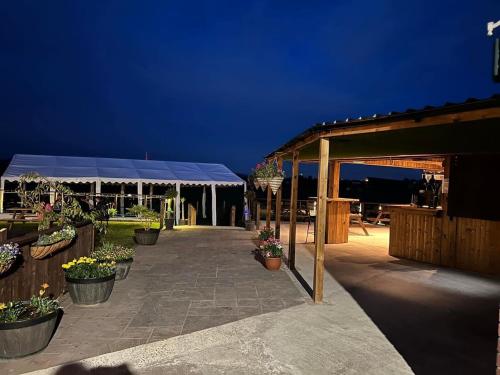 a patio with potted plants and a pavilion at night at The Hinds Head Hotel in Chorley