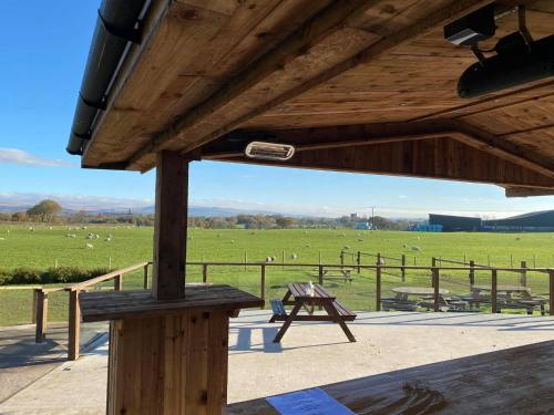a pavilion with a picnic table and a field of sheep at The Hinds Head Hotel in Chorley