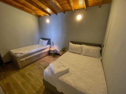 1 dormitorio con 2 camas en una habitación con suelo de madera en La escondida house, en Medellín