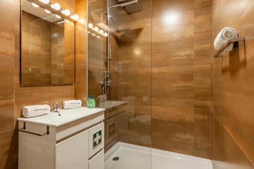 a bathroom with a sink and a glass shower at I Love Vila do Conde in Vila do Conde