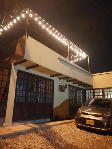 ein Auto, das vor einem Gebäude mit Lichtern parkt in der Unterkunft Hospedaje Miguel Ángel in Tabio