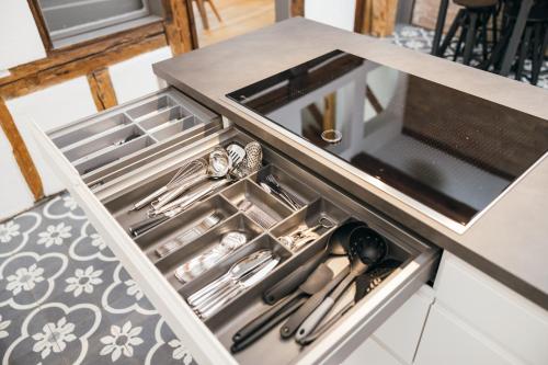 a drawer in a counter with silver utensils at HEIMATEL - Luxury Penthouse Loft in Ravensburg