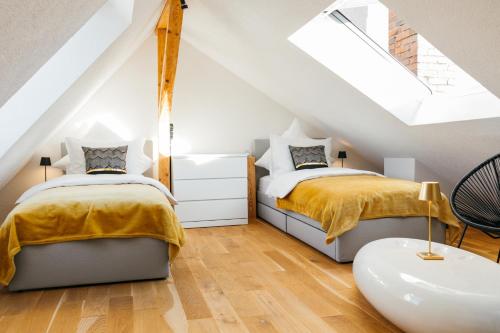 - 2 lits dans une chambre mansardée avec une lucarne dans l'établissement HEIMATEL - Luxury Penthouse Loft, à Ravensbourg