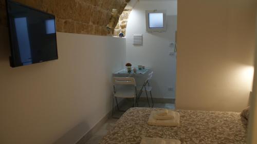 a bedroom with a bed and a sink in a room at La Mansio del Vicolo in Mola di Bari