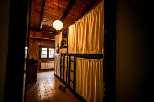 Um homem está numa sala com cortinas amarelas. em Anum Hostel em Ushuaia