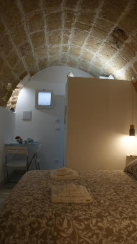 una camera con un letto e un tavolo con finestra di La Mansio del Vicolo a Mola di Bari