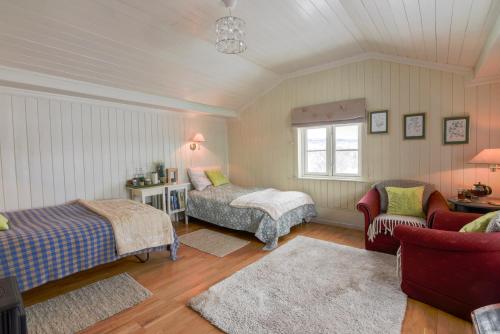 1 dormitorio con 2 camas, silla y ventana en Escapade Norvégienne, en Tolga