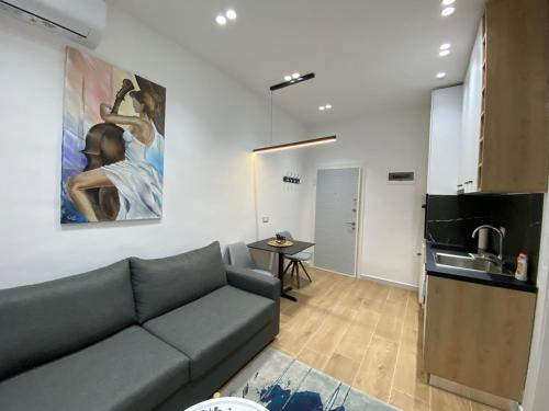 a living room with a couch and a kitchen at Apartament in Blloku in front of Taiwan in Tirana