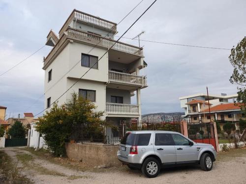 un furgone bianco parcheggiato di fronte a un edificio di Velipoja Family Apartment a Velipojë