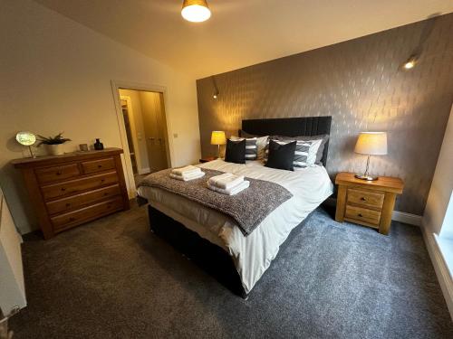 a bedroom with a large bed with two night stands and two lamps at The Buckie at Buchanan in Drymen