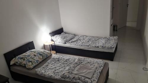 dwa łóżka siedzące obok siebie w pokoju w obiekcie RMF Naworol 7 w Szczecinie