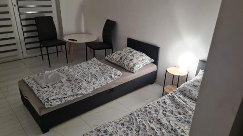 sypialnia z 2 łóżkami, stołem i krzesłami w obiekcie RMF Naworol 7 w Szczecinie