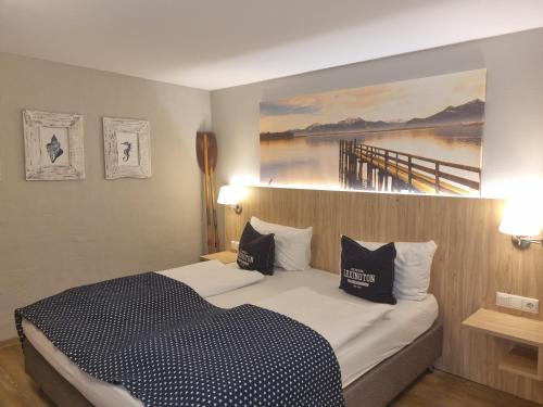 a bedroom with a bed with a painting on the wall at Gasthof Chiemseefischer in Grabenstätt