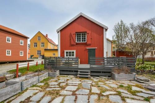 un edificio rojo con un banco delante de él en Sjøgata Riverside Rental and Salmon Fishing, en Mosjøen