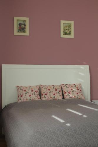 een slaapkamer met een bed met twee foto's aan de muur bij Spa Apartmán Kováčová in Kováčová