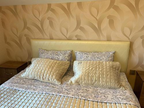 a bed with two pillows on top of it at Beautiful Guest House Qusar in Qusar