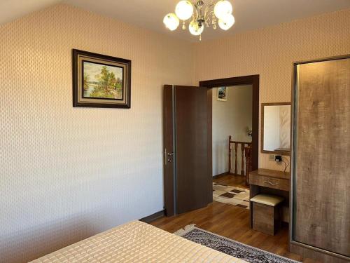 1 dormitorio con cama, tocador y espejo en Beautiful Guest House Qusar, en Qusar
