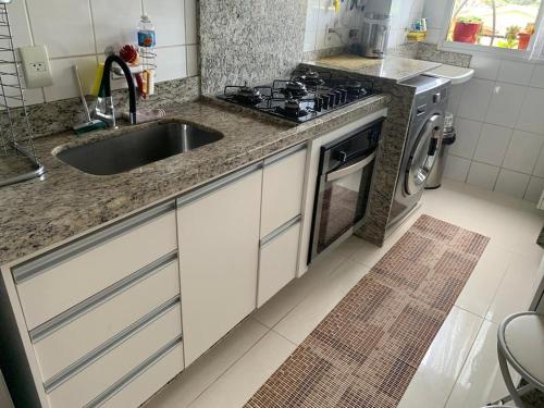 a kitchen with a sink and a stove at Apto com conforto que você precisa. in Goiânia