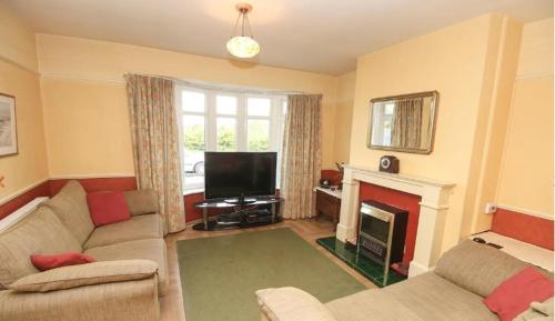 a living room with a couch and a fireplace at Wideopen in Seaton Burn