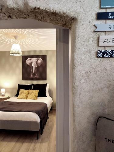 - une chambre avec un lit king-size et un mur en pierre dans l'établissement Entre Uzès et le Pont du Gard le Cocon de SOPHIA à deux pas des Gorges du Gardon, à Collias