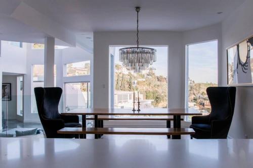comedor con mesa, sillas y ventana en Hollywood Hills Modern Sanctuary–Jaw Dropping View en Los Ángeles