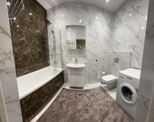 a bathroom with a sink toilet and a washing machine at Apartment in center of Chisinau in Chişinău