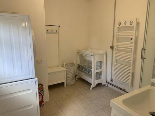 a white kitchen with a refrigerator and a sink at Maison village, 10 pers, proche de la plage in Audinghen