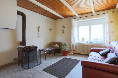 sala de estar con sofá y chimenea en Grande longère familiale pour 4 à 14 personnes, en Le Faouët