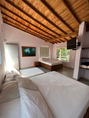 Habitación grande con 2 camas y TV. en Hotel Parador del Gitano, en Doradal