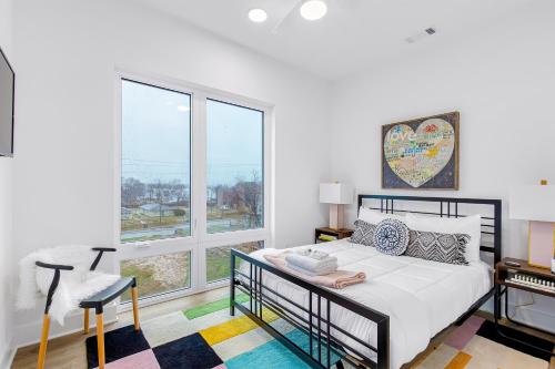 a bedroom with a bed and a large window at Jolene on Main 406 in Nashville