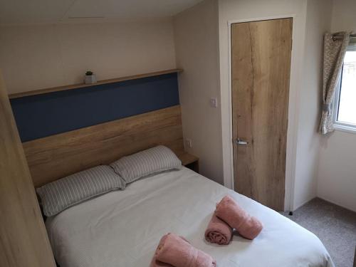 a bedroom with a bed with two towels on it at Plompton Mill Holiday Home in Knaresborough