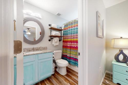 a bathroom with a toilet and a sink and a mirror at Vinyard Ventures, Unit #3 in Branson