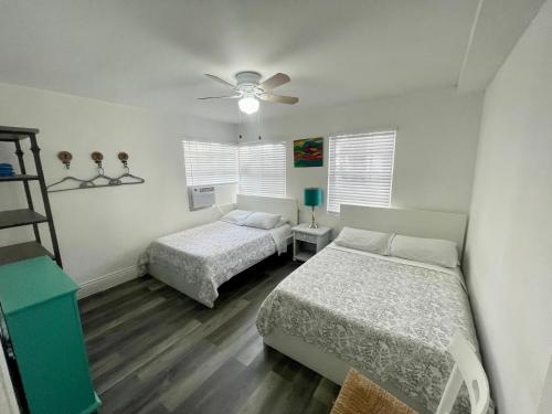 a bedroom with two beds and a ceiling fan at Sunflower Boutique Hotel Apartments in Miami Beach