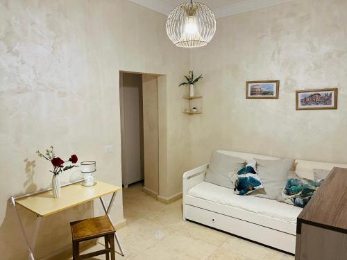 a living room with a white couch and a table at Colosseum apartment in Rome