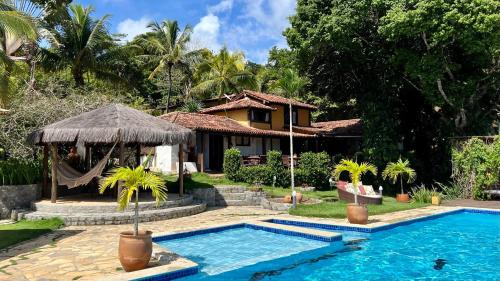 a resort with a swimming pool and a house at Pousada Mundo Verde in Trancoso
