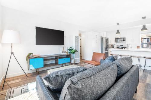 a living room with a couch and a flat screen tv at Aloha Amigos Surf Getaway in San Clemente