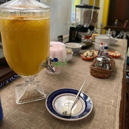 a drink in a glass on a table with a plate at Pousada Solar Azul in Miguel Pereira