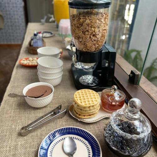 a table with a blender filled with food and cookies at Pousada Solar Azul in Miguel Pereira